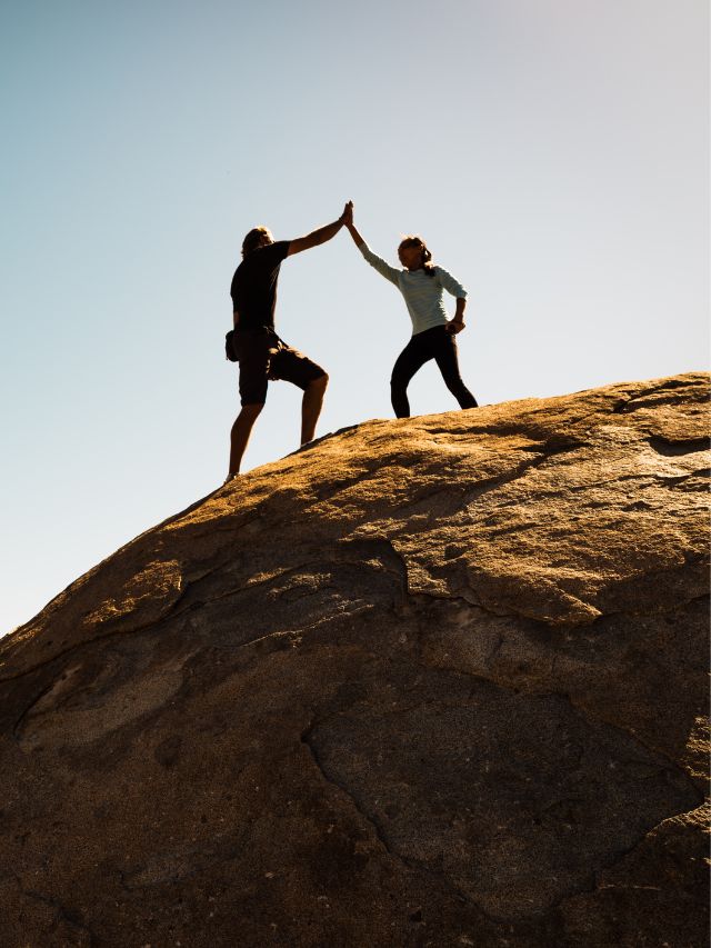 couple high five on cliff