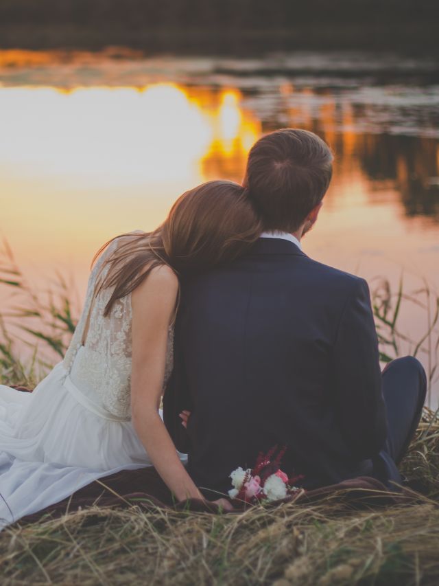 couple sitting by pond
