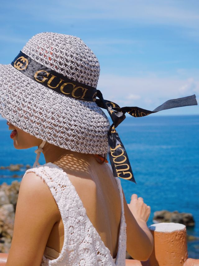 woman wearing a sun hat with gucci brand logo fake gucci vs real