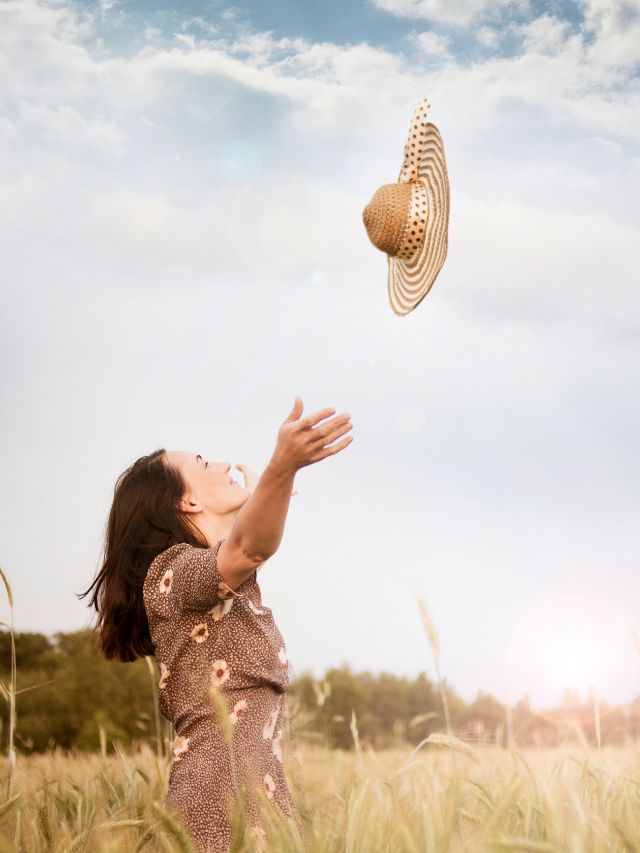 woman tossing hat in air