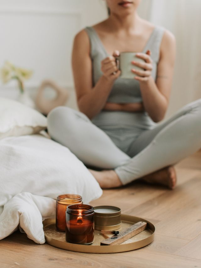 woman sitting on floor with candle