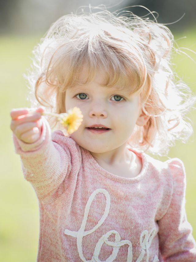 little girl holding flower