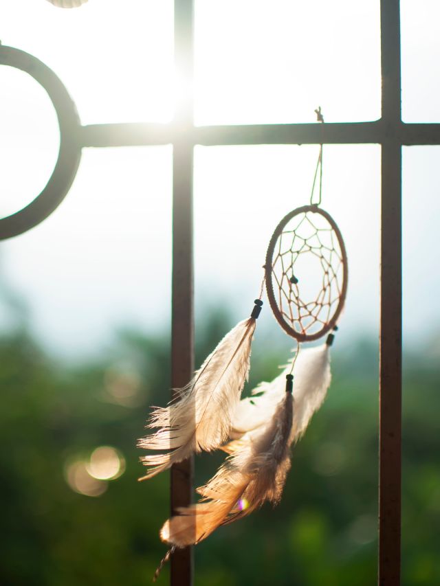 dream catcher hanging on a railing in the wind
