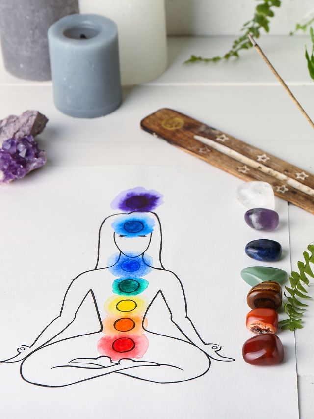 chakra painting on paper with crystals beside it