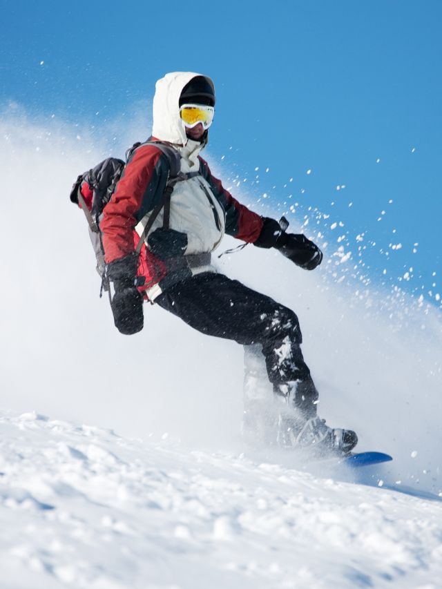 person snowboarding down slope