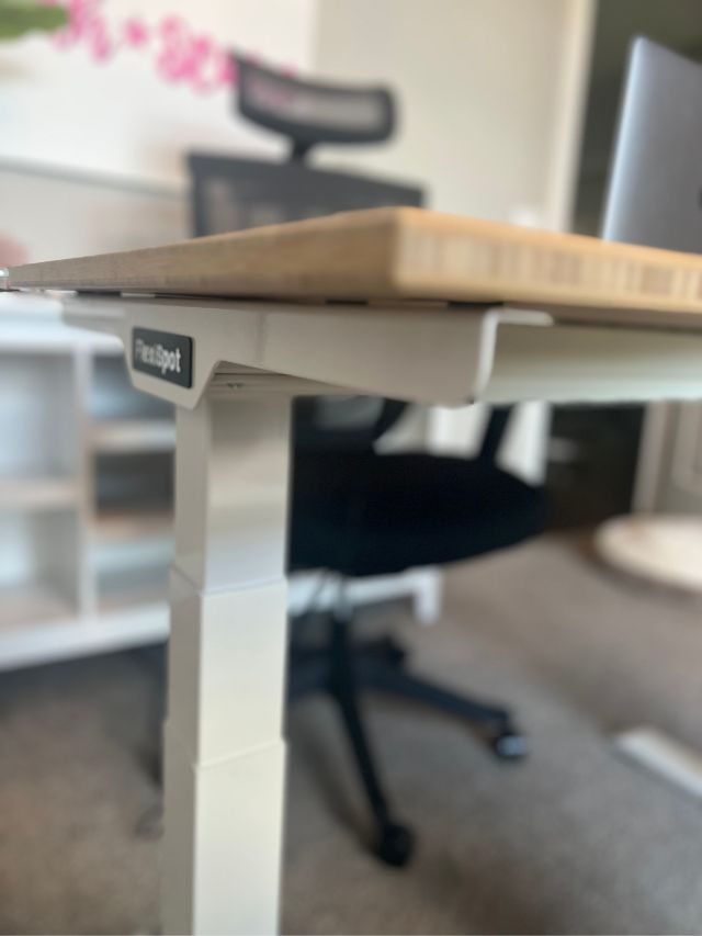 corner view of white and wood flexispot E7 standing desk