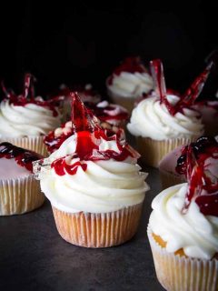A group of cupcakes topped with red and white frosting.