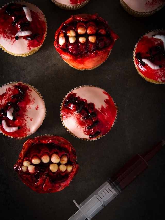 A group of cupcakes decorated with blood and syringes.