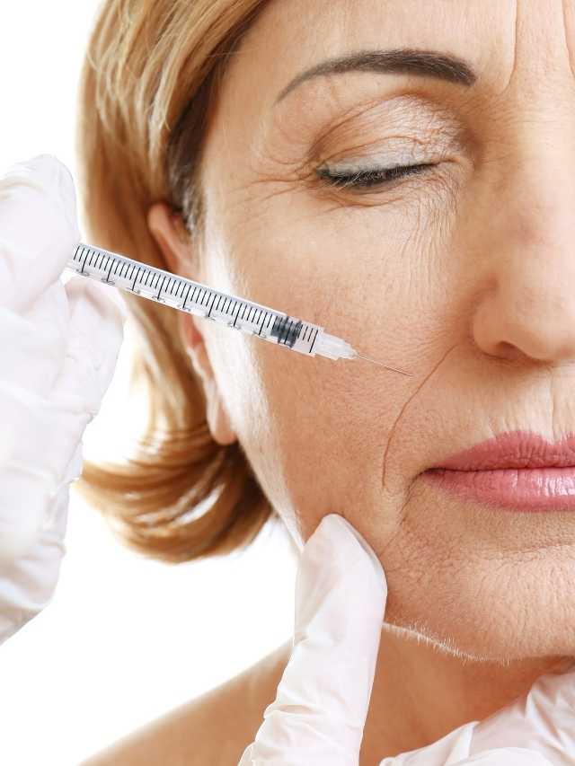 A woman is getting a syringe to inject her face.