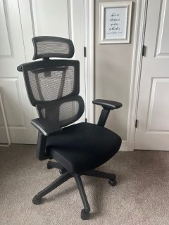 A black office chair in front of a door.