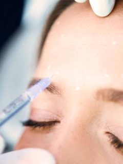 A woman getting a botox injection for her eyebrows.