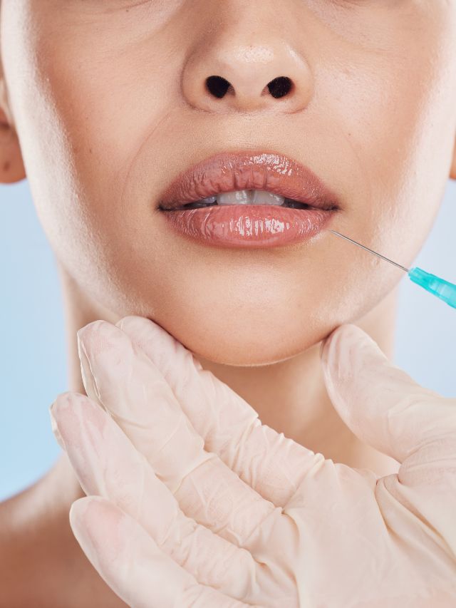 A woman's lips being injected with a syringe to enhance their appearance.