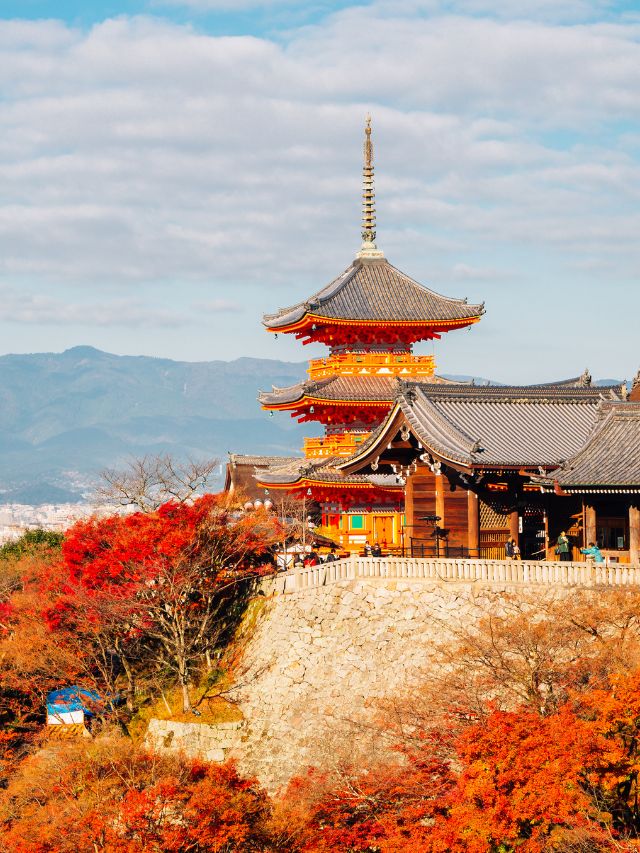 A japanese pagoda surrounded by autumn foliage.