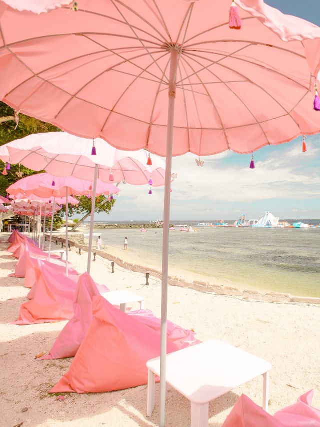Pink bean bags on the beach.