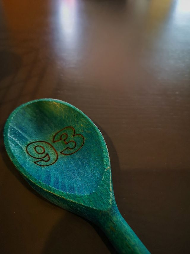 A wooden spoon with a number on it.