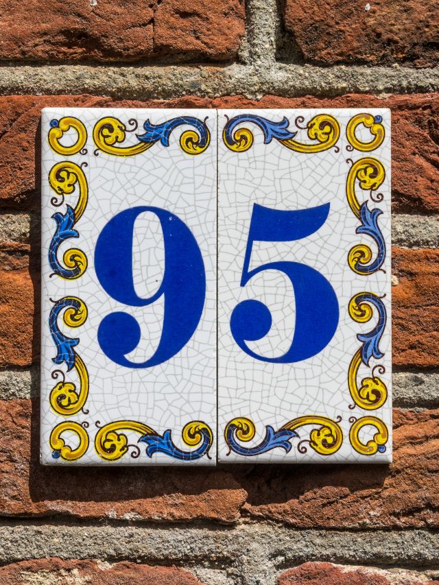 House number 95 on a brick wall.