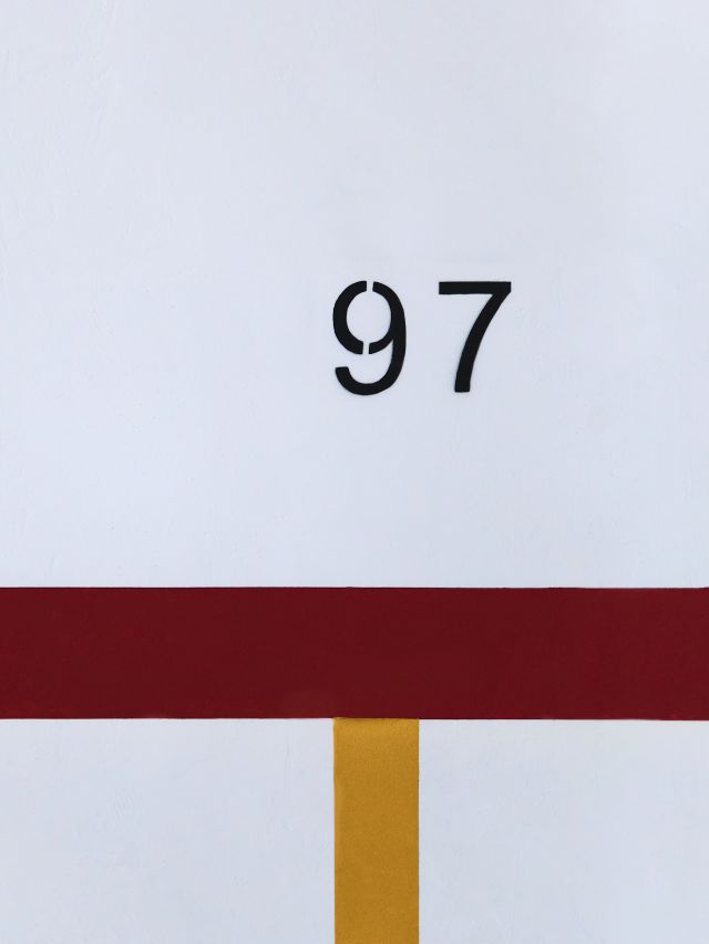 A red, yellow and white painting with the number 97 on it.