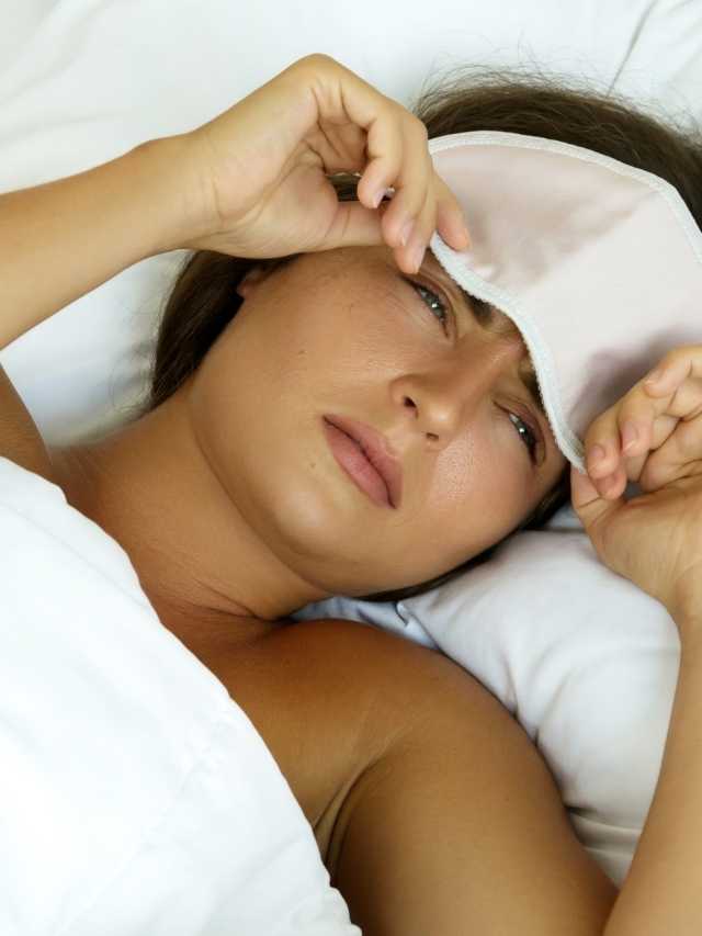A woman laying in bed with her eye mask on.