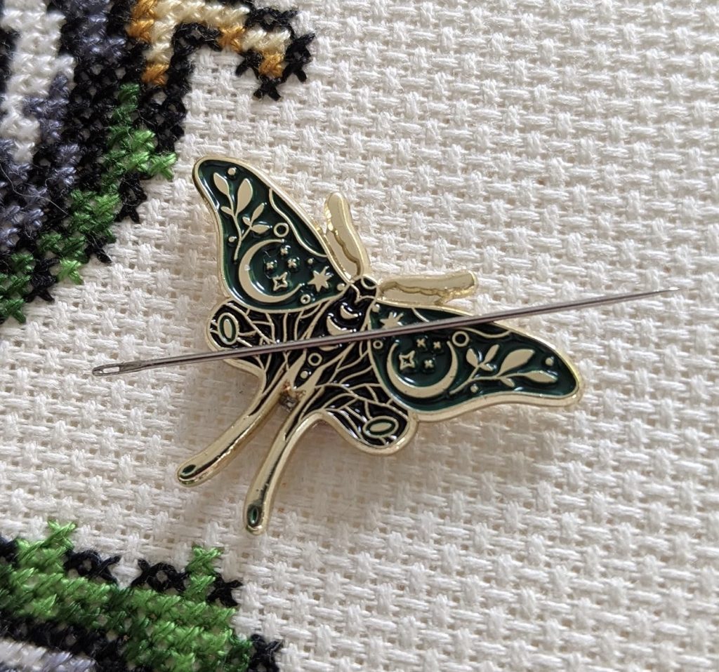 A needle-adorned butterfly brooch, perfect for quilters looking for Christmas gift ideas.