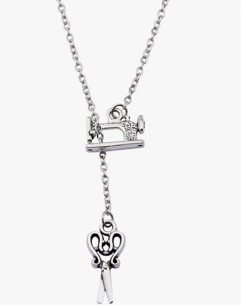 A silver necklace with a sewing machine charm, perfect for quilters as a Christmas gift idea.