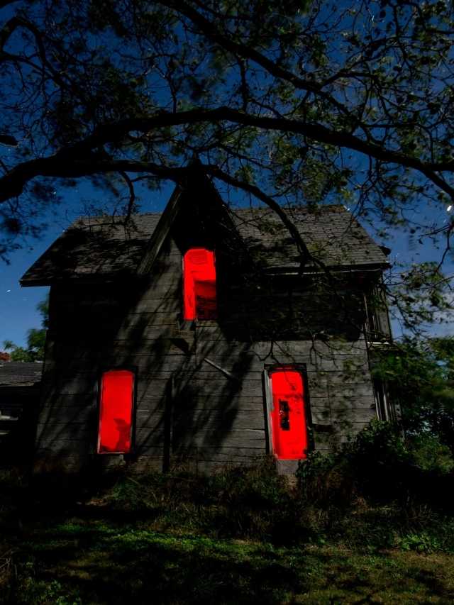A house is lit up with red lights at night.