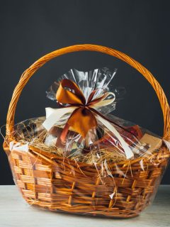 A wicker basket with chocolates in it on a dark background.