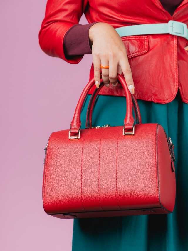 A woman holding a red handbag.