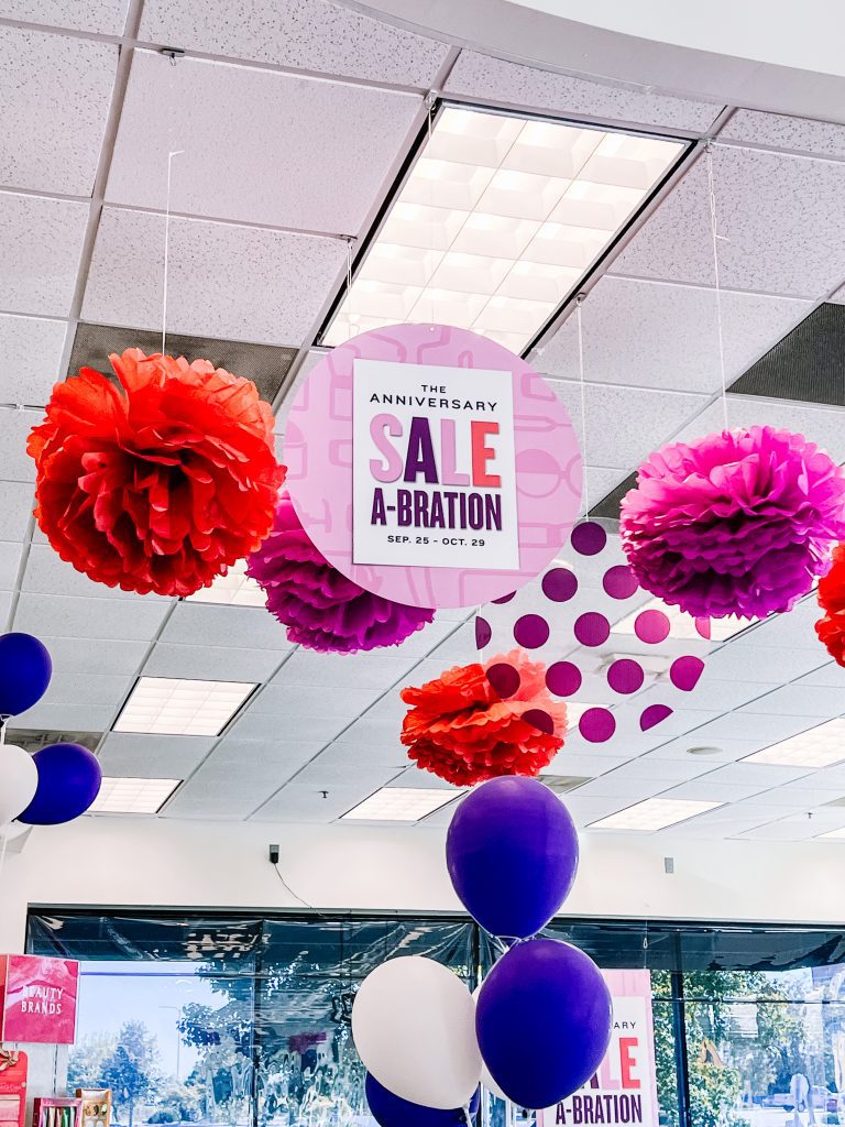 Beauty brands anniversary sale  with purple, blue, and white balloons hanging from the ceiling.