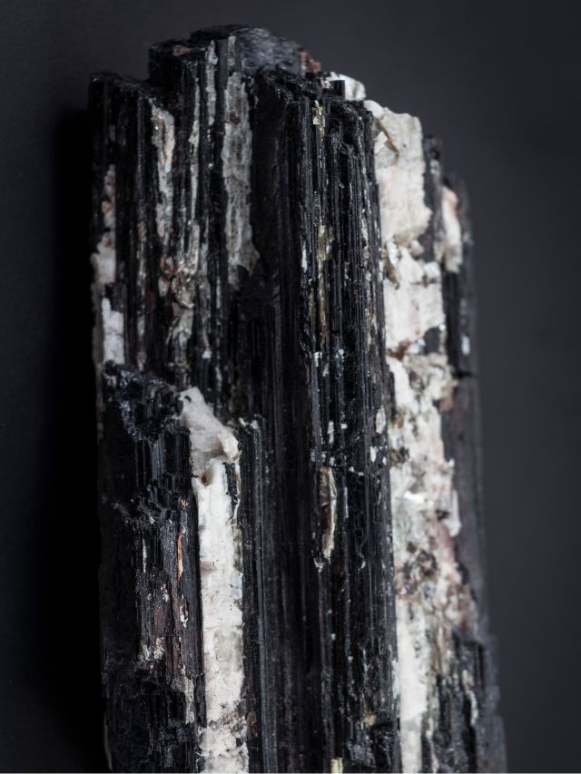 A piece of black and white mineral on a black background.