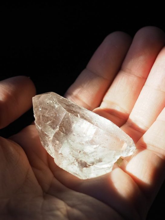 A person holding a piece of crystal in their hand.