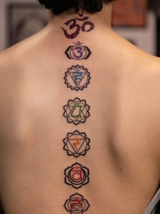 The back of a woman with various chakra tattoos.