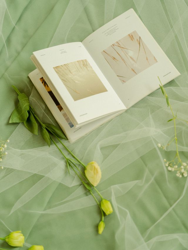 A book open on a green sheet with flowers on it, symbolizing love and the meaning of angel number 303.