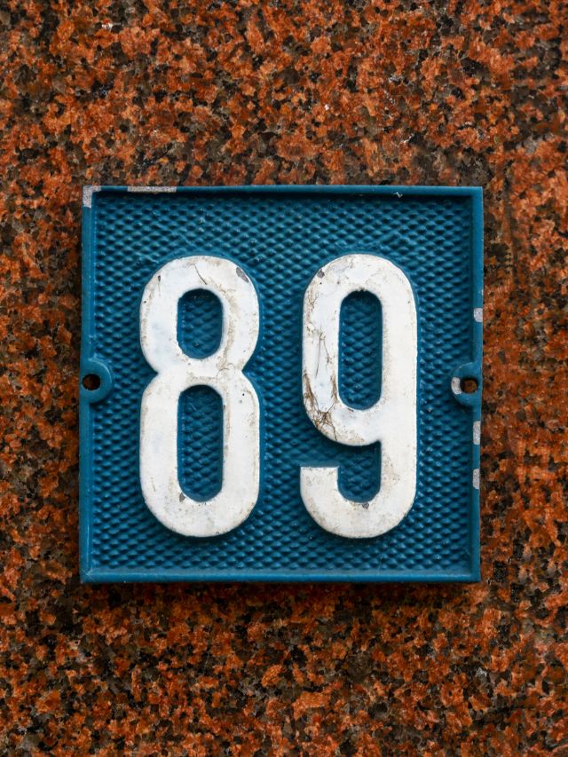 A blue metal number plate with the number 89, symbolizing angelic guidance and love.
