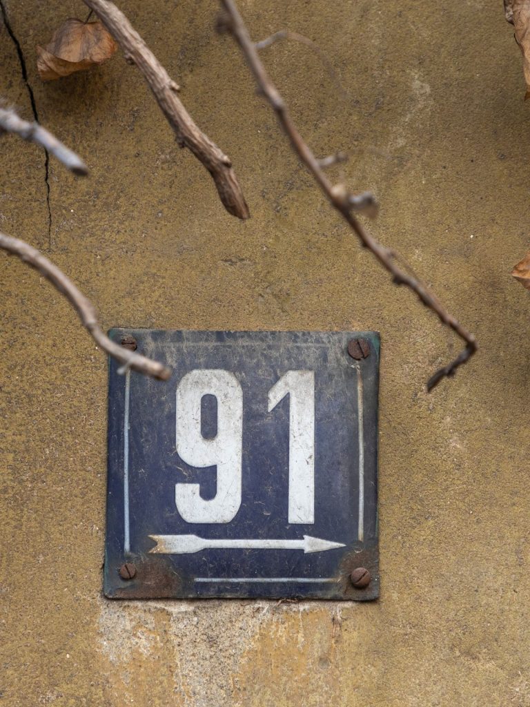 A metal number sign on a wall with angelic significance.