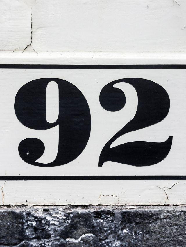 A black and white sign displaying the number 92.
