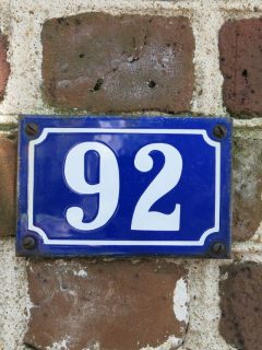 House number 92 on a brick wall with angelic significance.