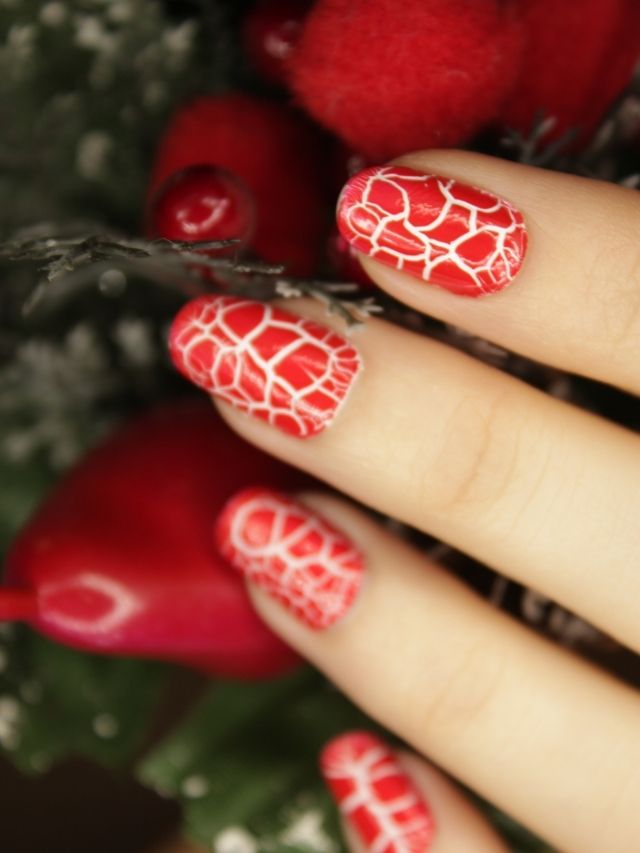 A woman's hand with red and white nail art.