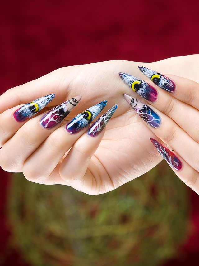 A woman's hand with colorful nail art on it.