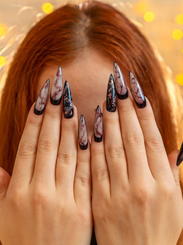 A girl with long nails covering her face with her hands.