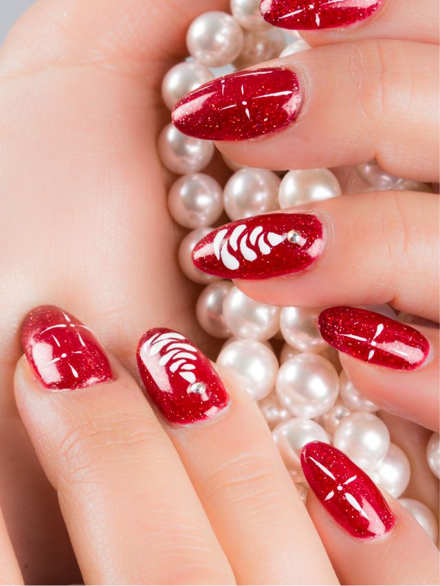A woman's hand with red nail polish and pearls.