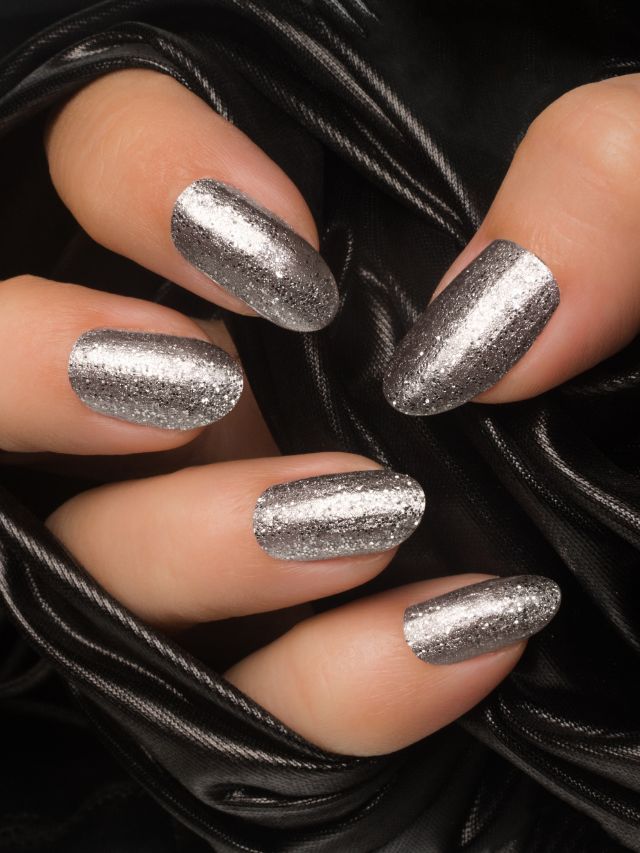 A woman's hand with silver nail polish.