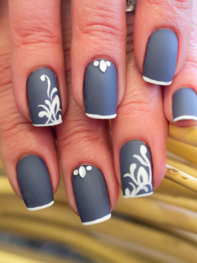 A woman's nails with gray and white designs.