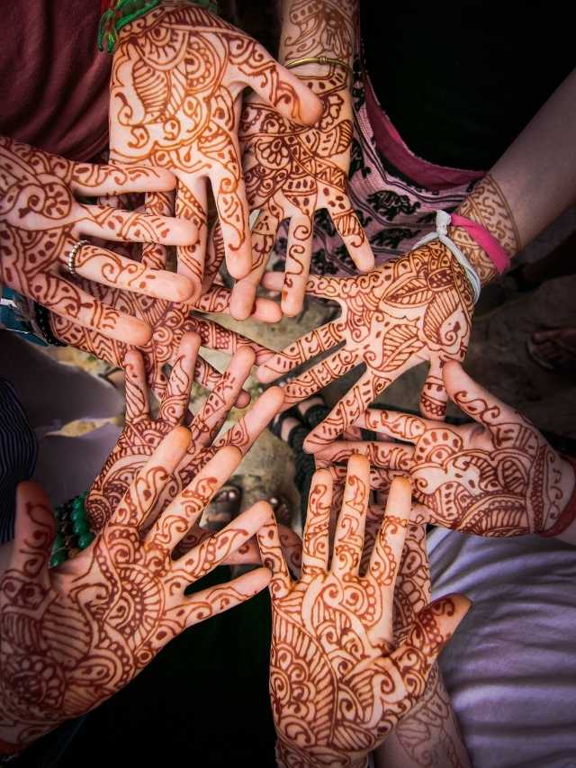 A group of people with henna tattoos on their hands.