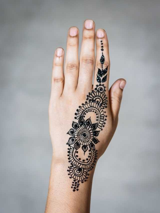 A woman's hand with a black henna tattoo.