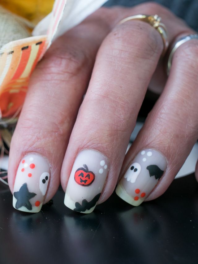 A woman's hand holding a halloween nail art design.