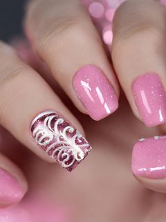 A woman with pink and white nail designs.