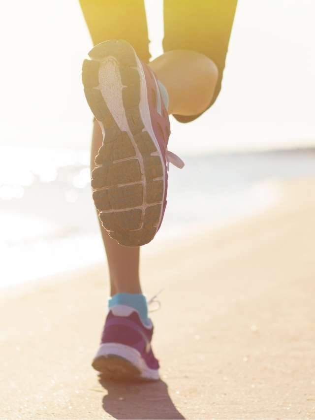 A woman jogging on the beach.