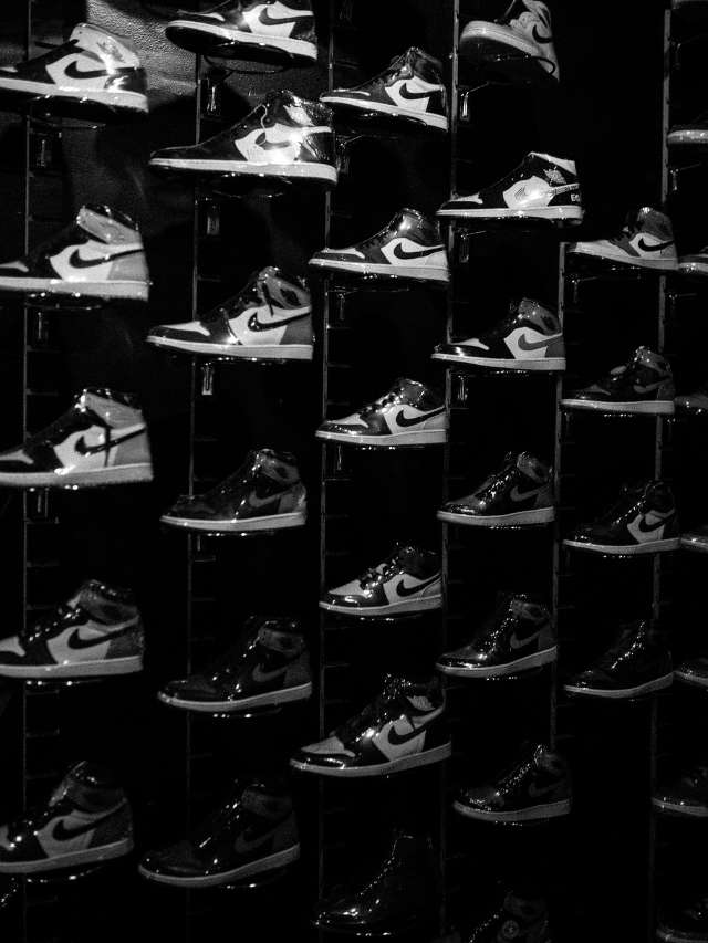 A black and white photo of many shoes on display.