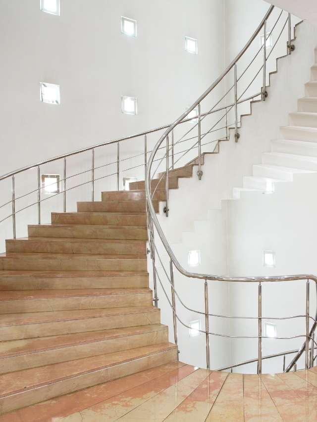 A staircase in a white building with metal railings.