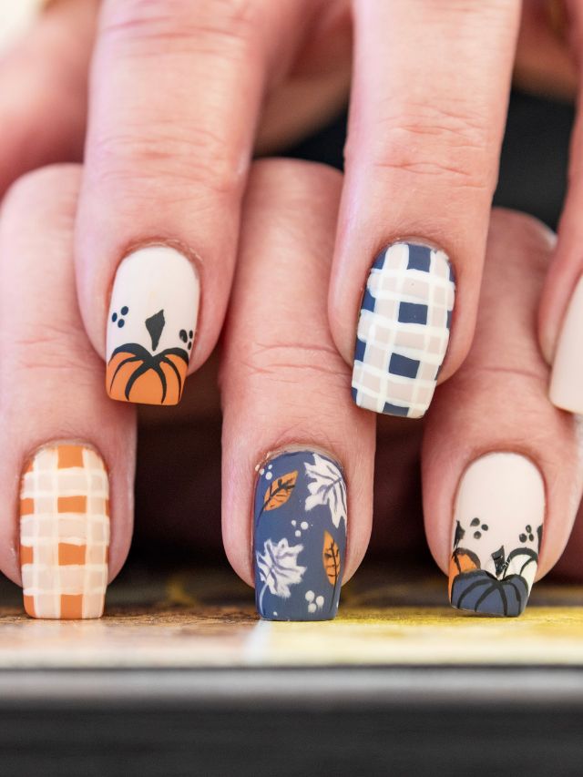 A woman's nails are decorated with pumpkins and plaid designs.